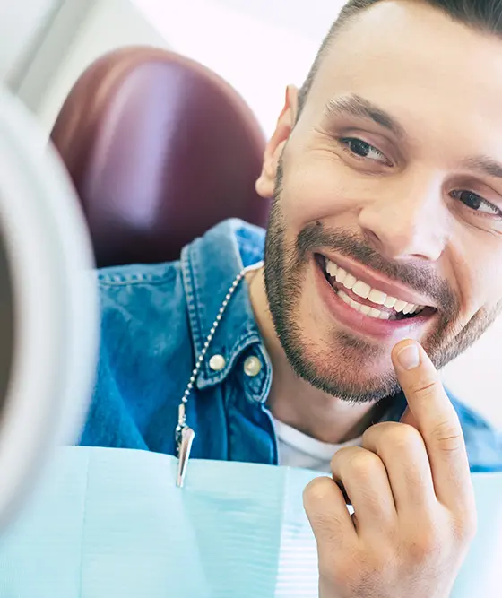 Patient Smiling Into Mirror Checking Gums