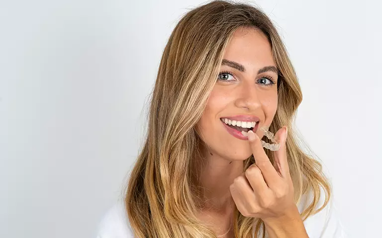 Woman Holding Invisalign Tray
